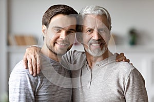 Portrait of happy old father and adult son hugging