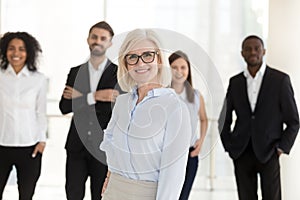 Portrait of happy older woman company ceo with diverse team