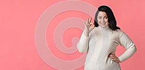 Portrait of happy oversized woman smiling and showing ok gesture