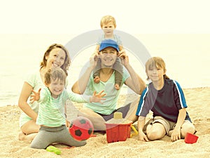 Portrait of happy parents and their children on sand