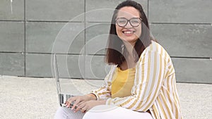 Portrait of happy plus size woman 30-35 years old working remotely on a laptop