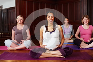 Portrait of happy pregnant women in yoga with leader or teacher teaching in training or class for fitness and meditation