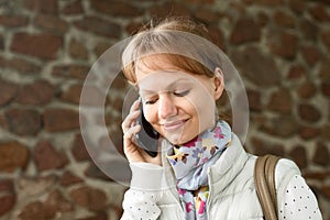 Portrait of happy pretty girl talking by cell phone and smiling