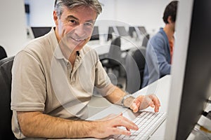 Portrait of happy professor working on computer