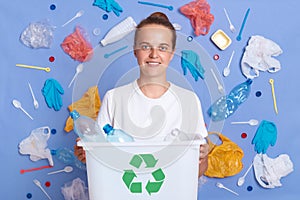 Portrait of happy responsible Caucasian woman eco activist with box full of plastic bottles for recycling, looking at camera,