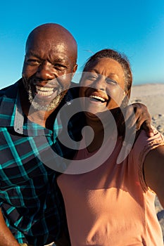 Portrait of happy retired african american senior couple enjoying together at beach