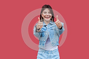 Portrait of happy satisfied beautiful brunette young woman with makeup in denim casual style standing, thumbs up and looking at