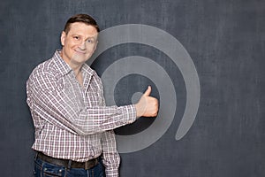 Portrait of happy satisfied man showing thumb up gesture