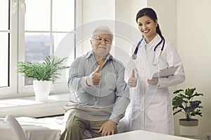 Portrait of happy satisfied senior man and young doctor giving thumbs up together