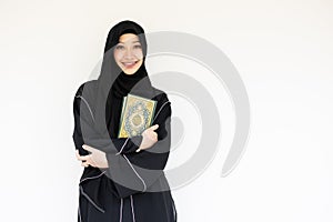Portrait happy Saudi muslim niqab arab woman black chador with The Holy Al Quran book isolated on white. book cover arabic