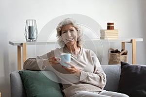 Portrait of happy senior 60s woman holding cup