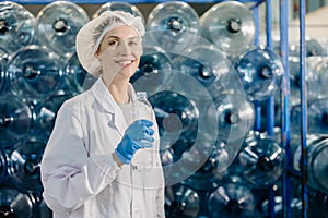 portrait happy senior adult caucasian women worker work in drinking water plant factory with clean drink water bottle