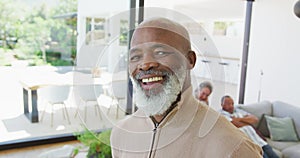 Portrait of happy senior african american man with other seniors at retirement home