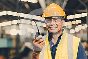 portrait happy senior Asian engineer worker staff working radio operate team in heavy industry metal factory