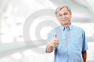 Portrait of happy senior asian man gesture hand showing thumb up or good sign and looking at camera