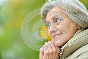 Portrait of happy senior beautiful woman in autumnal park