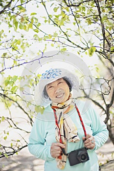 Portrait of happy senior beautiful woman in spring park