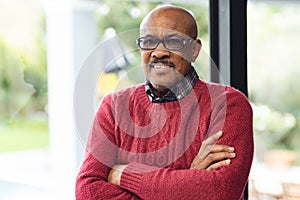 Portrait of happy senior biracial man wearing glasses smiling at home
