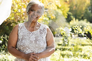 Portrait of happy senior biracial woman smiling in sunny garden at home, copy space