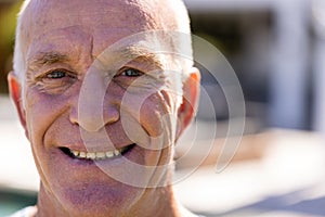 Portrait of happy senior caucasian man looking at camera and smiling in sunny garden