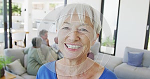 Portrait of happy senior caucasian woman with other seniors at retirement home