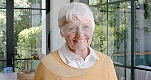 Portrait of happy senior caucasian woman smiling at home, slow motion