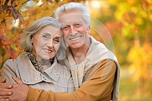 Portrait of happy senior couple in autumn park