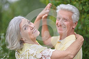 Portrait of happy senior couple dancing in park