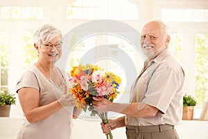 Portrait of happy senior couple with flower