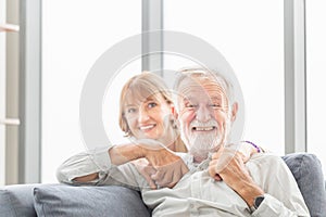 Portrait of happy senior couple in living room, Elderly man and woman relaxing on cozy sofa at home, Happy family concepts