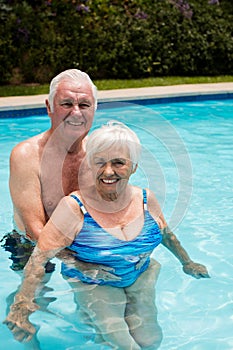 Portrait of happy senior couple in the pool
