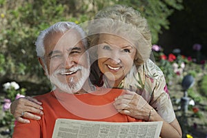 Portrait Of A Happy Senior Couple Reading Newspaper