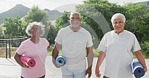 Portrait of happy senior diverse people practicing yoga in garden at retirement home