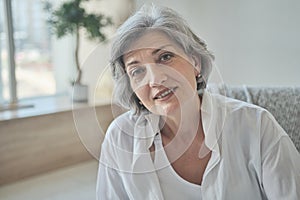 Portrait of a happy senior elderly woman in a bright comfortable apartment.