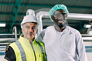 Portrait happy senior engineer with hygiene black african male worker standing together friendly in food factory industry