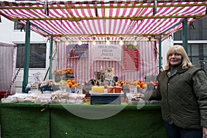 Portrait of a happy senior fruit stall owner standing in market