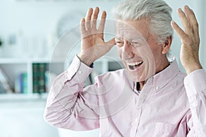 Portrait of happy senior man at home