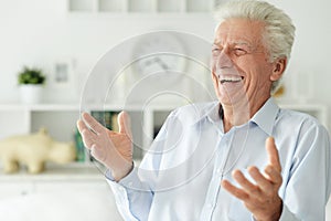 Portrait of happy senior man at home