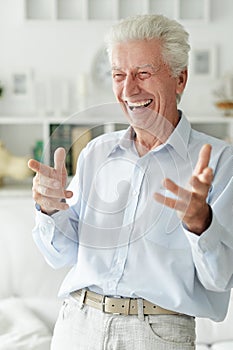 Portrait of happy senior man at home