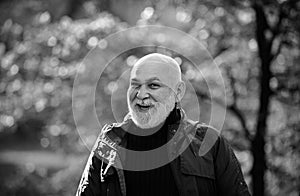 Portrait of a happy senior man outdoors, walking in a park.