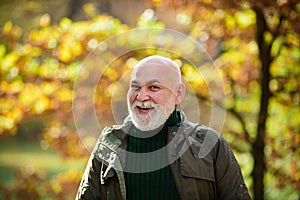 Portrait of a happy senior man outdoors, walking in a park.