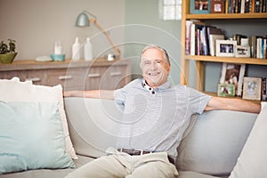 Portrait of happy senior man sitting at home