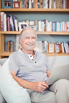 Portrait of happy senior man using laptop