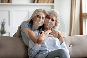 Portrait of happy senior mom and adult daughter hugging