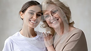 Portrait of happy senior mom and adult daughter hugging