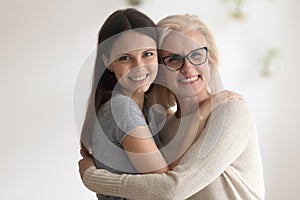 Portrait of happy senior mother and adult daughter embracing