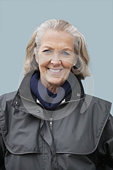 Portrait of happy senior woman against blue background