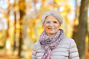 Portrait of happy senior woman at autumn park
