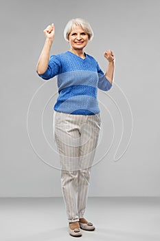 Portrait of happy senior woman celebrating success