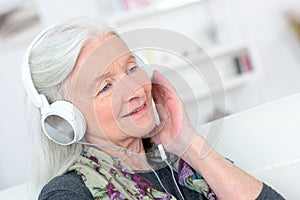 Portrait happy senior woman enjoying music with headphone